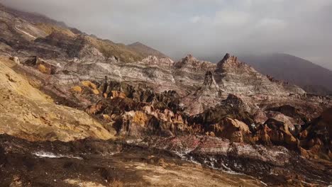 Wonderful-salt-mountain-colorful-rock-geology-natural-landscape-martial-view-rainbow-hills-amazing-panoramic-grey-gold-color-drone-shot-in-middle-east-Asia-Iran-highlands-fog-clouds-on-peak-in-hiking