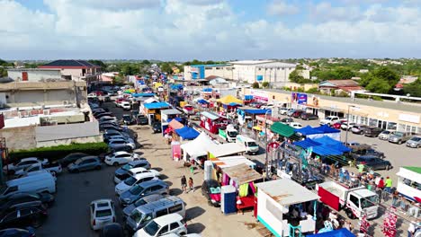 Ascenso-Aéreo-Desde-El-Estacionamiento-Sobre-El-Gran-Desfile-De-Carnaval-Lleno-De-Emocionantes-Carrozas-En-Willemstad-Curacao