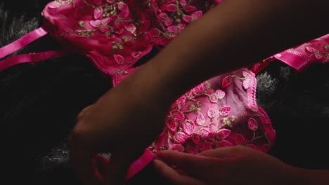 A-woman's-hand-caresses-the-pink-lingerie-before-dressing-it