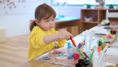 Niña-Preescolar-Mezcla-Colores-En-Recipientes-Con-Gotero-Durante-La-Lección-De-Acuarela-De-Dibujo-Por-Goteo