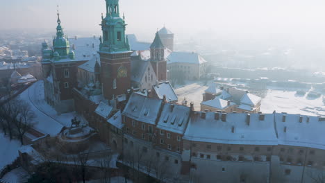 Snow-covered-Wawel-castle-at-magic-morning-with-soft-sun-light-during-winter,-Krakow,-Poland