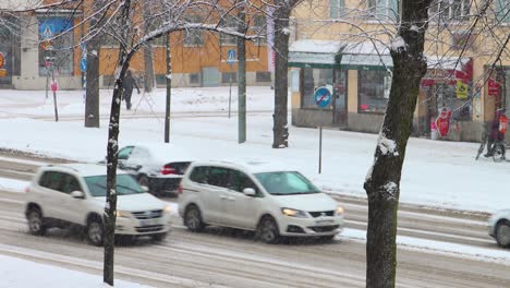 Traffic-on-wide-snowy-street-in-Stockholm,-Sweden-in-2021