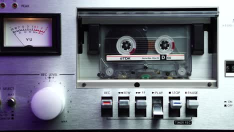 Platzieren-Und-Starten-Einer-Audiokassette-In-Einem-Vintage-Deck-Player-Mit-VU-Meter-Spitzenpegel,-Nahaufnahme