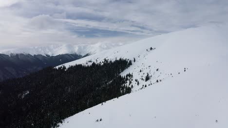Schneebedeckte-Iezer-Papusa-Berge-Mit-Dichtem-Wald-In-Arges,-Rumänien,-Ruhige-Naturszene