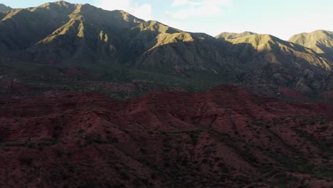 Montañas-áridas-Bajo-El-Sol,-Cañones-Rojos-Irregulares-En-La-Sombra,-Antena