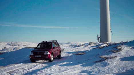Im-Winter-Ist-In-Bessaker,-Provinz-Trondelag,-Norwegen,-Ein-Auto-In-Der-Nähe-Der-Windmühle-Geparkt-–-Handaufnahme