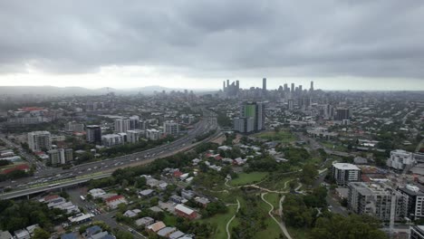 Tilt-up-Reveal-Of-Brisbane-Skyline-With-Overcast-From-Hanlon-Park-In-Queensland,-Australia