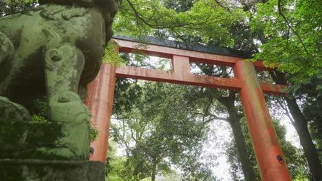 Niedrige-Ansicht-Des-Großen-Roten-Torii-Tors-Neben-Der-Statue-Im-Nara-Wald