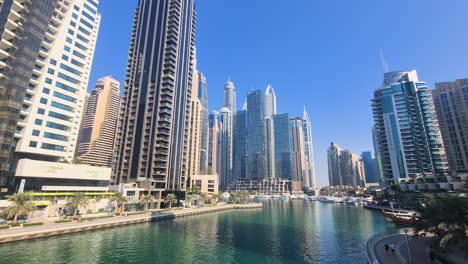 Dubai-Marina,-Emiratos-Árabes-Unidos-En-Un-Día-Caluroso-Y-Soleado,-Rascacielos-Residenciales-Frente-Al-Mar-Y-Canales