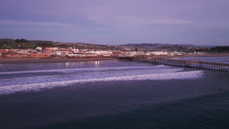 Dramatische-Drohnenaufnahme-Der-Wellen-Am-Pismo-Beach,-Die-Bei-Sonnenuntergang-Ans-Ufer-Krachen