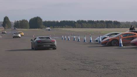 static-shot-of-supercars-driving-slowly-through-the-pit-lane-ready-to-race