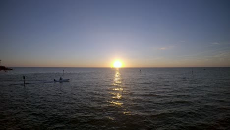 Luftaufnahmen-In-4K-Drohnenqualität-Von-Einem-Boot,-Das-über-Den-Golf-Von-Mexiko-Segelt,-Während-Im-Hintergrund-Die-Sonne-Untergeht