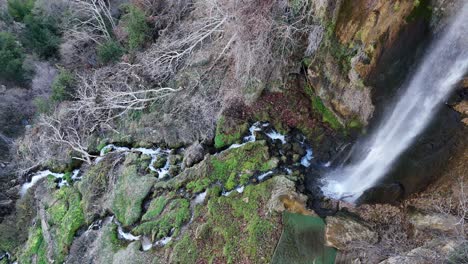 Blick-Auf-Einen-Natürlichen-Wasserfall-Auf-Abschüssigem-Gelände,-Bild-Des-Wasserflusses-Zwischen-Braunen-Felsen