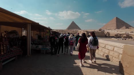 Touristen-Gehen-An-Souvenirläden-In-Der-Nähe-Der-Sphinx-Und-Der-Großen-Pyramiden-Entlang,-Einer-Historischen-Stätte