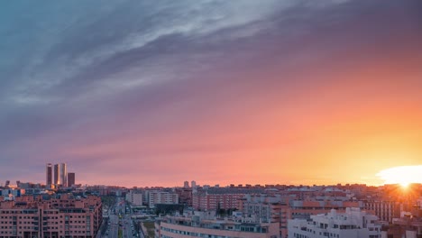 Timelapse-skyline-of-modern-european-city-Madrid-during-sunset-with-golden-light-and-red-clouds-during-blue-hour-zoom-in-day-to-night-time-lapse-copy-space-rule-of-thirds