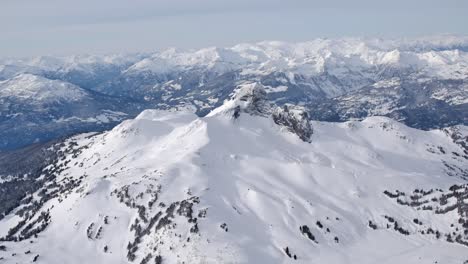 Weitwinkel-Luftaufnahme-Der-Schneebedeckten-Bergkette-An-Einem-Kalten,-Sonnigen-Wintertag