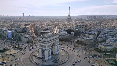 Arco-Triunfal-O-Arco-De-Triunfo-Y-Tráfico-De-Automóviles-En-La-Rotonda-Con-La-Torre-Eiffel-En-El-Fondo,-Francia