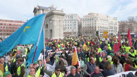 Panning-shot-of-Spanish-farmers-and-agricultural-unions-block-the-roads-as-they-gather-at-Puerta-de-Alcalá-in-Madrid-to-protest-against-unfair-competition,-agricultural-and-government-policies