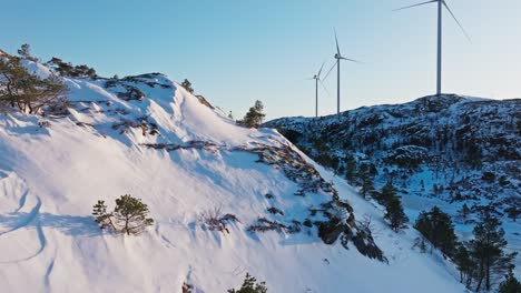 Snow-Covered-Mountains-And-Wind-Turbines-In-Bessaker,-Norway---Drone-Shot