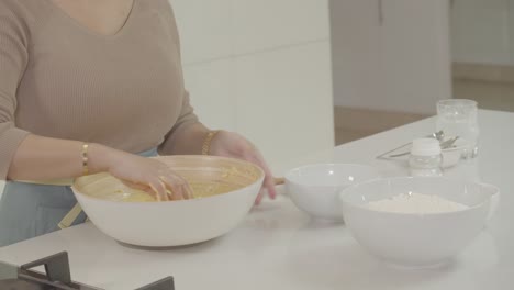 Die-Hand-Eines-Kochs-Streut-Kristallzucker-über-Den-Brotteig-In-Einer-Auflaufform