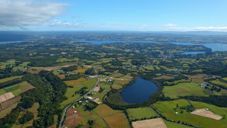 Luftbild-Drohnenlandschaft-Der-Insel-Lemuy,-Chiloé,-Chilenische-Patagonien-Insel-Mit-Grünen-Landwirtschaftlichen-Feldern-Und-Skyline