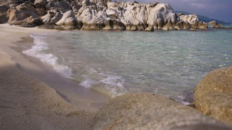 Primer-Plano-Del-Agua-Clara-Salpicando-La-Playa-De-Kavourotripes-En-Sithonia,-Chalidiki,-Grecia