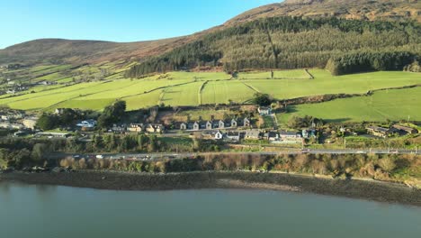 Carlingford,-County-Louth,-Ireland---The-Scenic-Coastal-Town,-with-the-Majestic-Slieve-Foy-Mountain-as-its-Backdrop---Aerial-Panning