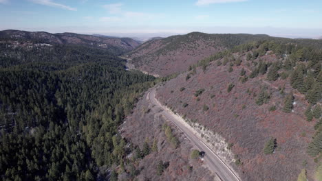 Toma-De-Drone-De-Una-Carretera-De-Montaña-Y-Un-Bosque-De-Pinos.