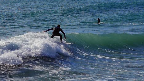 Slow-motion-:-male-surfer-surfing-the-wave-and-crashing-in-Barcelona,-Spain