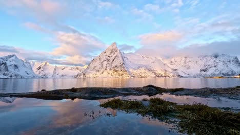 The-Olenils-island-and-Olstinden-mountain-in-winter-sunset,-Rings-in-water-slowly-moving,-Lofoten