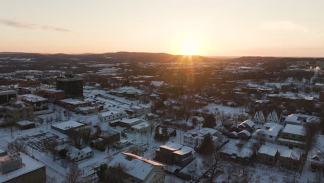 Fayetteville,-Arkansas-Bei-Sonnenaufgang-Mit-Schneebedeckten-Dächern-Im-Winter,-Warmer-Schein-über-Der-Stadt,-Luftaufnahme
