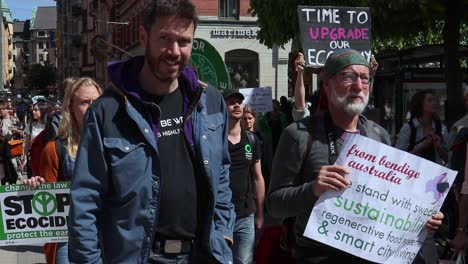 Protesters-march-with-signs-in-English-at-environmental-rally,-slomo