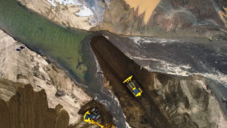 Top-view-of-heavy-machines-moving-sediment-after-a-river-changed-its-course