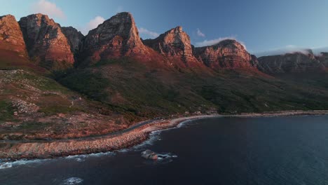 Victoria-Road-With-Twelve-Apostles-Mountains-In-Cape-Town,-South-Africa---Aerial-Drone-Shot