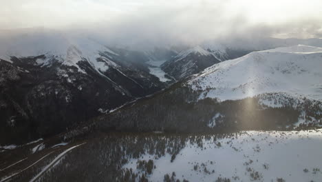 Snow-sunny-blizzard-Berthoud-Pass-Winter-Park-scenic-landscape-view-aerial-drone-sun-flare-backcountry-ski-snowboard-Berthod-Jones-Colorado-Rocky-Mountains-peaks-high-elevation-backward-motion
