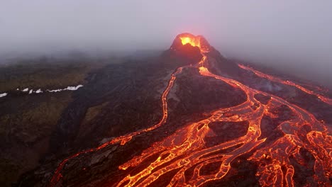 Aerial-cinematic-footage-captured-by-a-4K-drone-depicts-a-volcano-erupting-lava,-with-the-molten-streams-cascading-down-from-its-peak