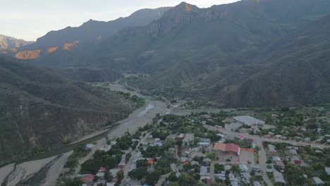 Aerial-drone-natural-environment-valley-small-town,-copper-canyon-Urique-mexico-road-crossing-between-mountain-range-of-north-latin-America