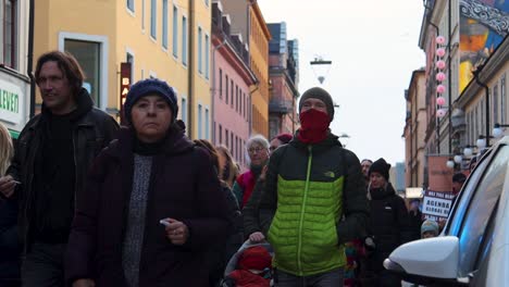 People-in-winter-clothes-walk-in-Covid-protest-march,-Sweden,-slomo