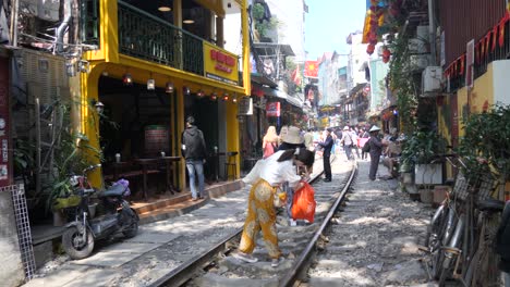 Bustling-Hanoi-Train-Street-with-people-and-vibrant-shops,-daytime