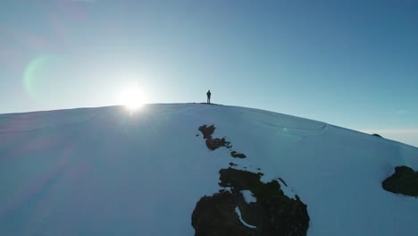 Eine-Person-Steht-Auf-Einem-Schneebedeckten-Berg,-Mit-Der-Sonne-Im-Rücken,-In-Frankreich