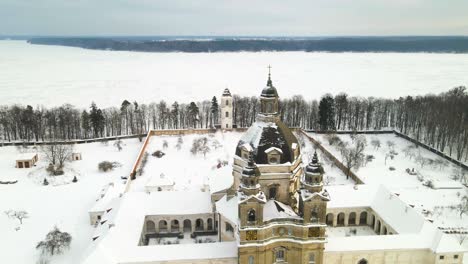 Aerial-view-of-the-Pazaislis-monastery-and-the-Church-of-the-Visitation-in-Kaunas,-Lithuania-in-winter,-snowy-landscape