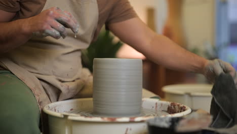 Männliche-Töpferhände-Bearbeiten-Nassen-Ton-Auf-Töpfer-Drehscheibe-In-Atelier-Werkstatt-Aus-Nächster-Nähe