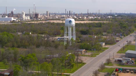 Drone-view-of-Baytown,-Texas-water-tower-and-refineries-in-the-background