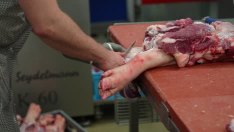 Butcher-doing-abbatoir-slaughterhouse-operations-and-cutting-pig-leg