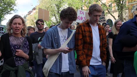 Young-protesters-look-bored-at-climate-march-in-Sweden,-static-slomo