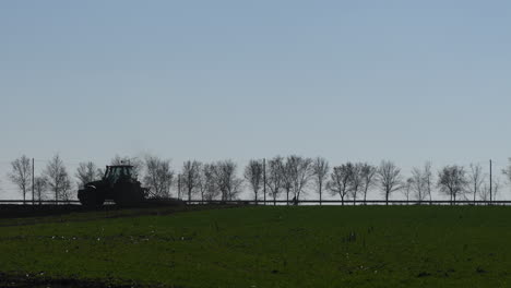 Silhouette-Der-Landwirtschaftlichen-Traktor-Mit-Fräse-Im-Feld