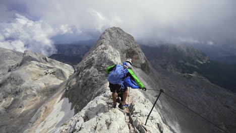 Among-the-jagged-rocks,-hikers-ascend-Triglav,-driven-by-adventure