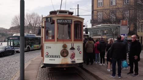 Historic-Tram-in-Porto-Awaiting-Passengers-at-Riverside-Stop-for-a-Scenic-City-Journey-Along-the-Picturesque-Waterfront