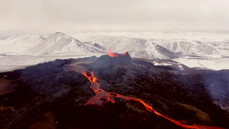 Aerial-cinematic-shots-from-a-4K-drone-capture-the-unique-beauty-of-a-volcano-and-cascading-lava,-set-against-the-scenic-backdrop-of-the-majestic-Alps-mountain-range