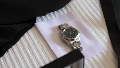 Groom-wedding-accessories-on-pattern-blanket,-expensive-watch-close-up
